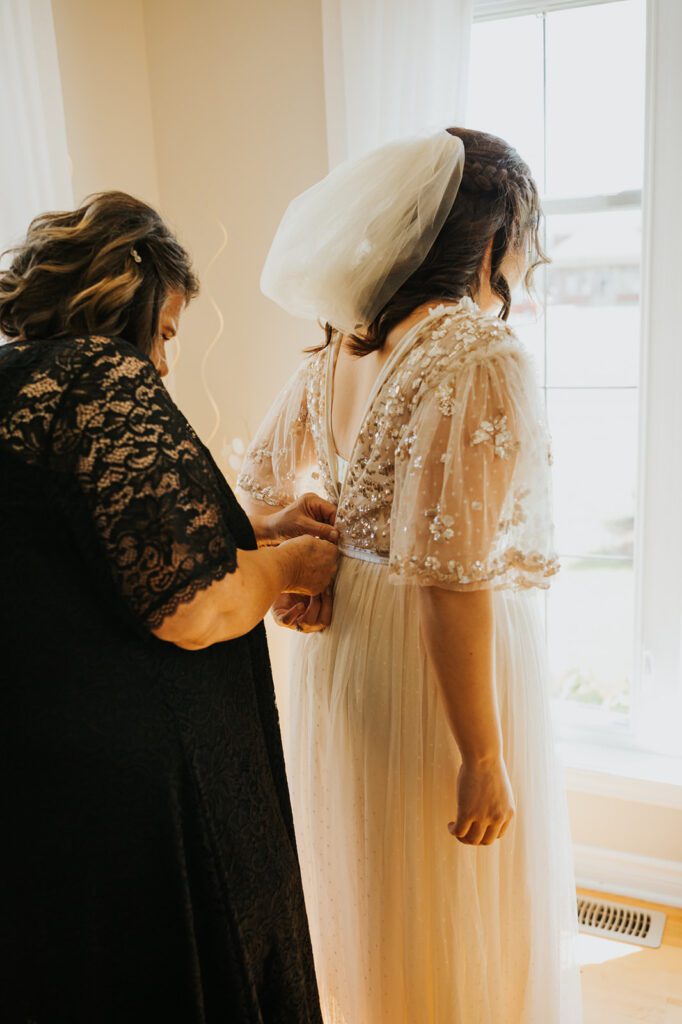 Kimberly's mom helping her put her dress before her wedding day at mouton village