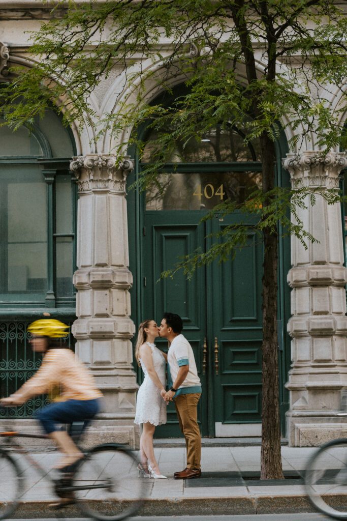 bicycles going by as this couple kisses in old montreal