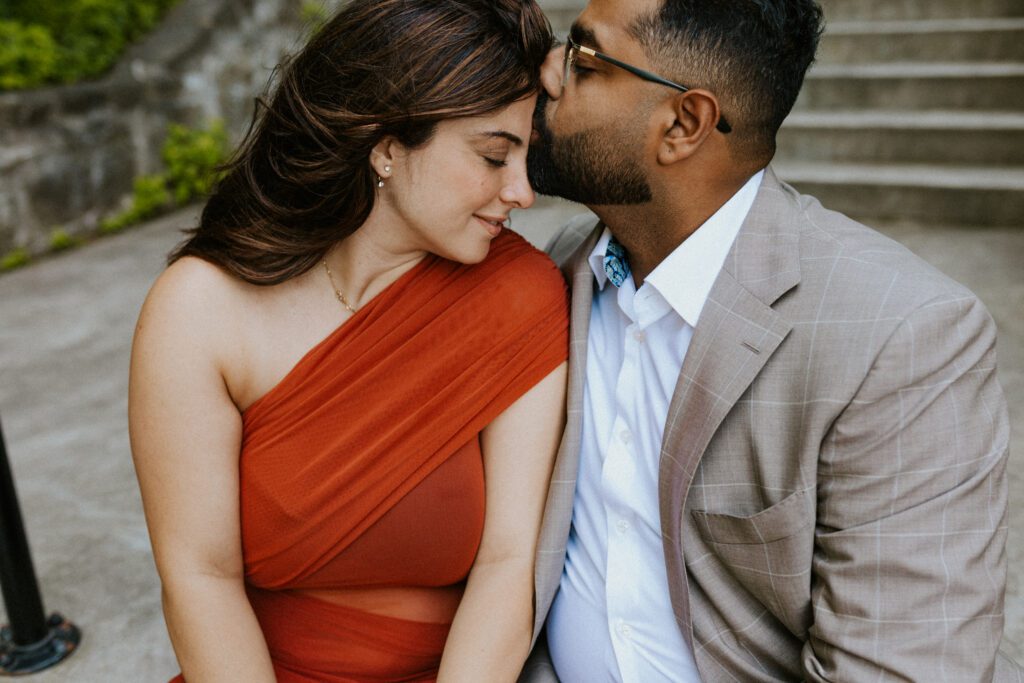 he is kissing her forehead during their engagement shoot
