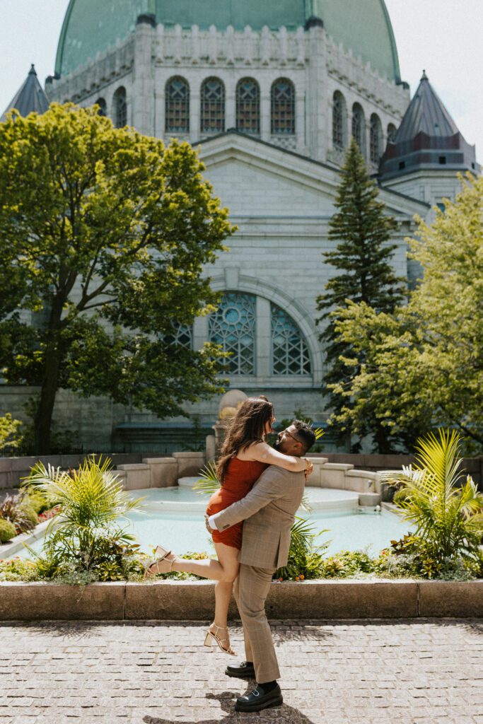 he is lifting her up in front of the fountain at the st-joseph oratory