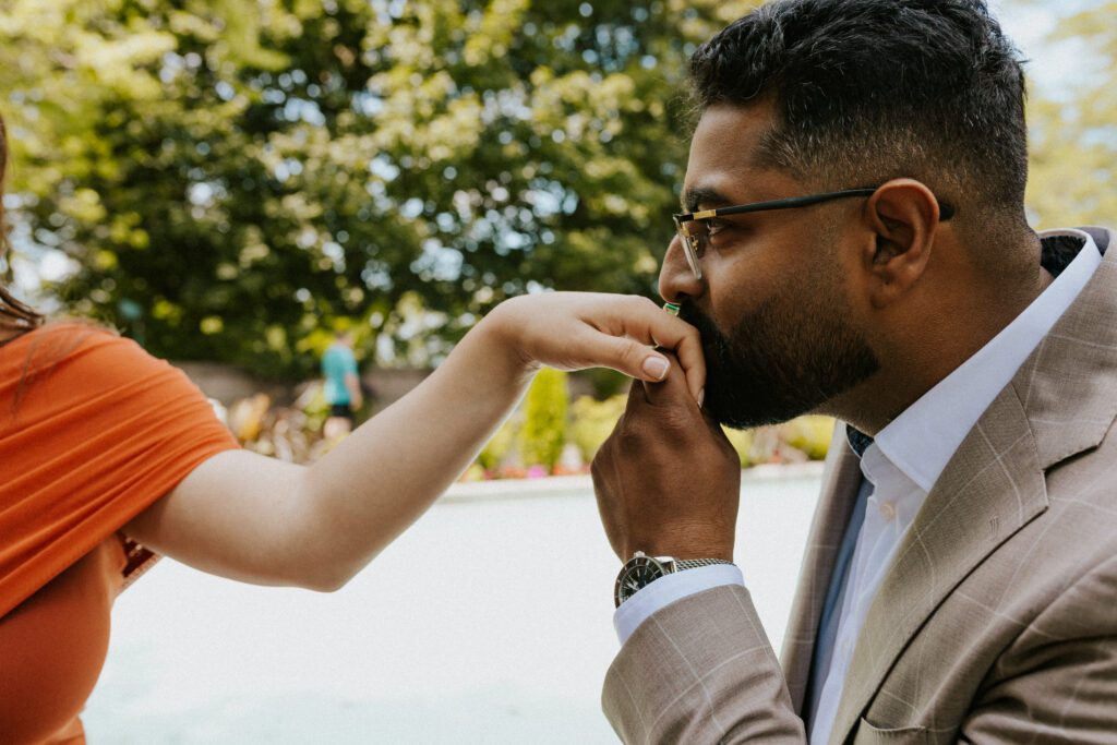 he is kissing her hand during their engagement session at the oratory